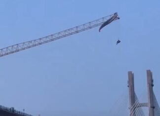 Завис на высоте 60 метров: в Китае парапланерист зацепился за строительный кран